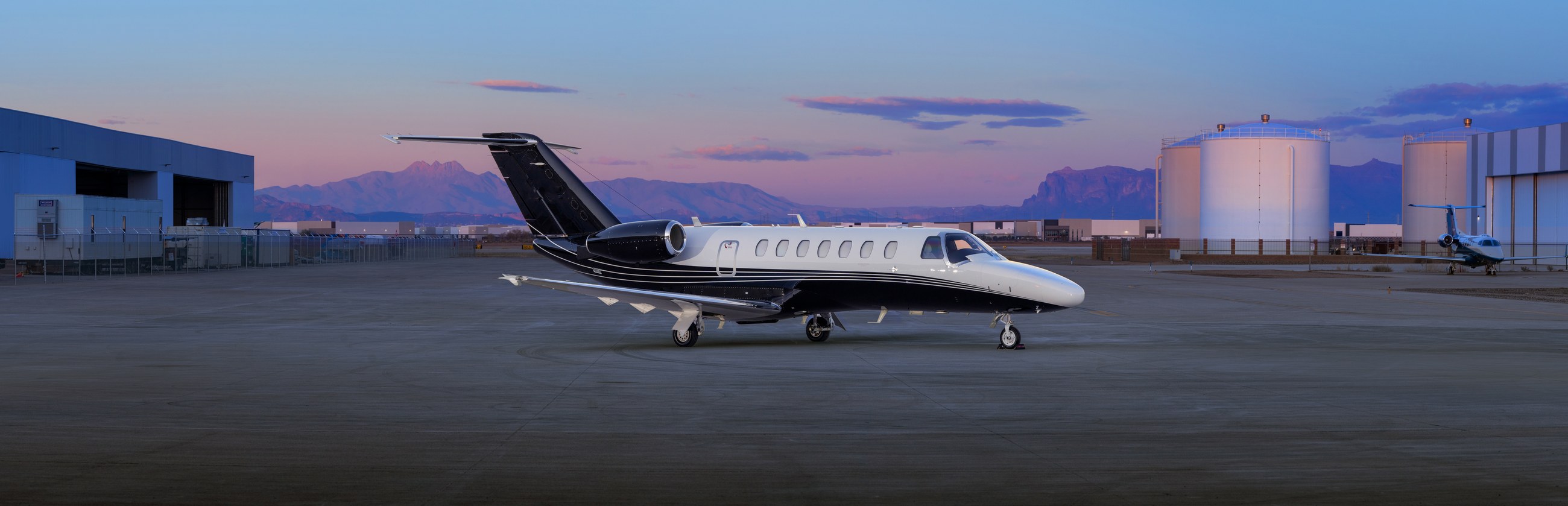 Cessna Citation jet on the ramp at dusk, the Superstition Mountains beyond
